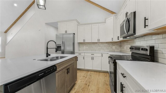 1778 Country Club Dr, Lake Ozark, MO 65049 - kitchen with appliances with stainless steel finishes, light countertops, decorative backsplash, white cabinets, and high vaulted ceiling