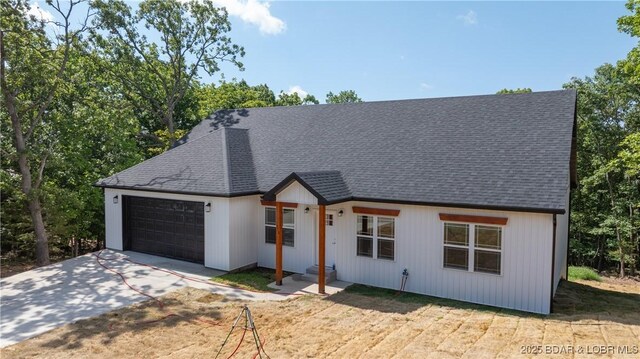 1778 Country Club Dr, Lake Ozark, MO 65049 - modern farmhouse featuring a garage, driveway, and roof with shingles