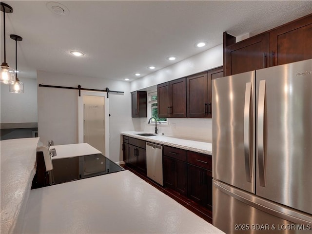25 Primrose Ln, Camdenton, MO 65020 - kitchen with stainless steel appliances, a barn door, dark brown cabinetry, light countertops, and recessed lighting