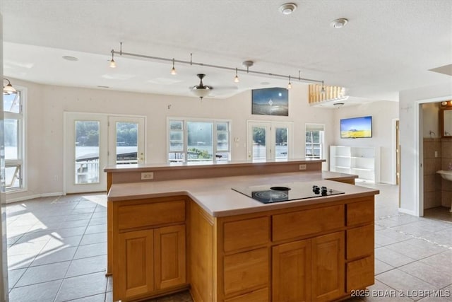 29773 Hemlock Rd, Gravois Mills, MO 65037 - kitchen featuring open floor plan, black electric stovetop, light tile patterned floors, light countertops, and french doors