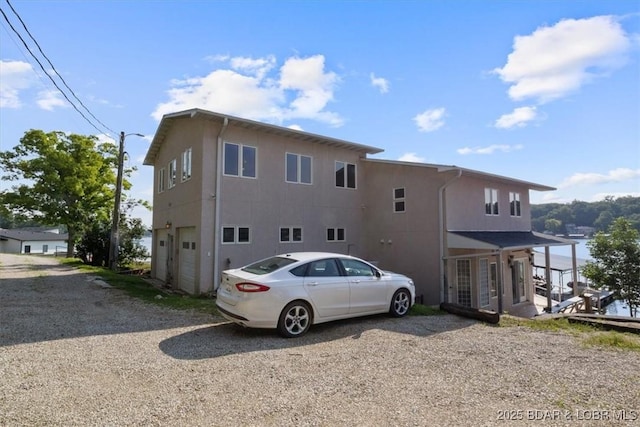 29773 Hemlock Rd, Gravois Mills, MO 65037 - back of property with driveway, stucco siding, and an attached garage