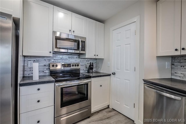 172 Kansas City Way, Sunrise Beach, MO 65079 - kitchen with appliances with stainless steel finishes, dark countertops, backsplash, and light wood finished floors