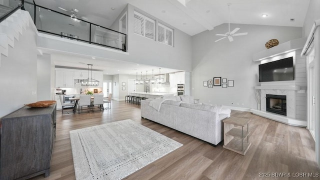 5450 Christopher Dr Unit 243, Osage Beach, MO 65065 - living room with ceiling fan, high vaulted ceiling, a high end fireplace, wood finished floors, and a chandelier