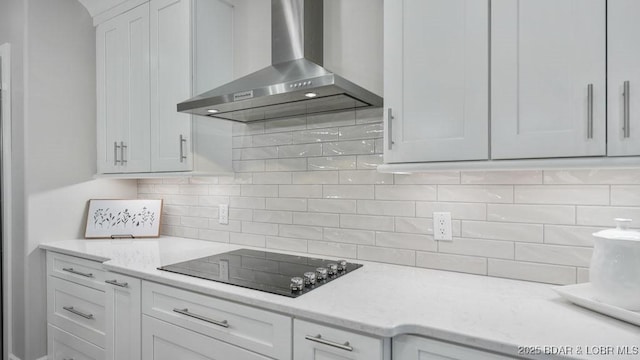 5450 Christopher Dr Unit 243, Osage Beach, MO 65065 - kitchen featuring wall chimney exhaust hood, black electric cooktop, white cabinetry, tasteful backsplash, and light stone countertops