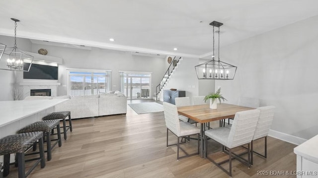 5450 Christopher Dr Unit 243, Osage Beach, MO 65065 - dining space featuring a chandelier, stairs, recessed lighting, light wood finished floors, and a fireplace