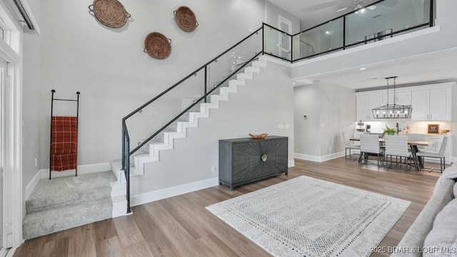 5450 Christopher Dr Unit 243, Osage Beach, MO 65065 - entryway featuring a high ceiling, stairway, wood finished floors, and a chandelier