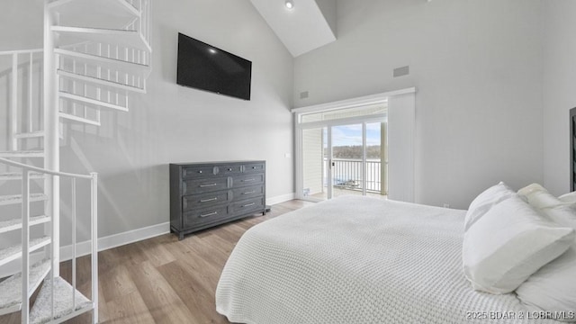 5450 Christopher Dr Unit 243, Osage Beach, MO 65065 - bedroom with high vaulted ceiling, access to exterior, and wood finished floors