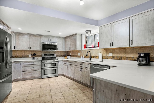30383 Bullock Dr, Gravois Mills, MO 65037 - kitchen featuring appliances with stainless steel finishes, tasteful backsplash, light tile patterned floors, and light countertops