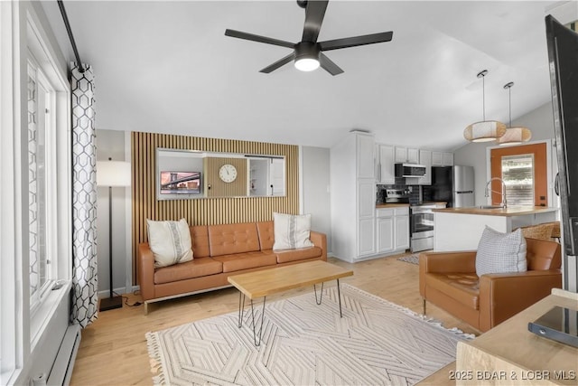 26794 Boone Rd, Barnett, MO 65011 - living area featuring a ceiling fan, light wood-style floors, baseboard heating, and vaulted ceiling