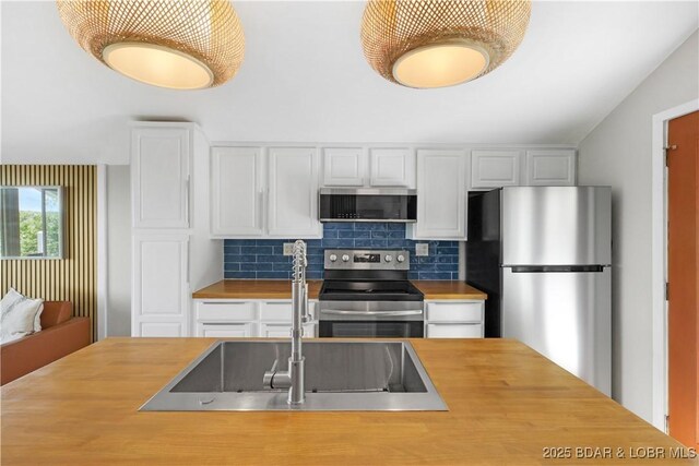 26794 Boone Rd, Barnett, MO 65011 - kitchen featuring stainless steel appliances, wood counters, white cabinets, and backsplash