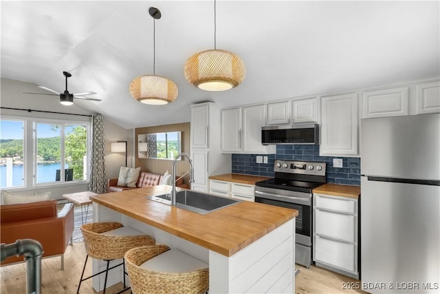 26794 Boone Rd, Barnett, MO 65011 - kitchen with stainless steel appliances, butcher block counters, open floor plan, light wood-type flooring, and lofted ceiling