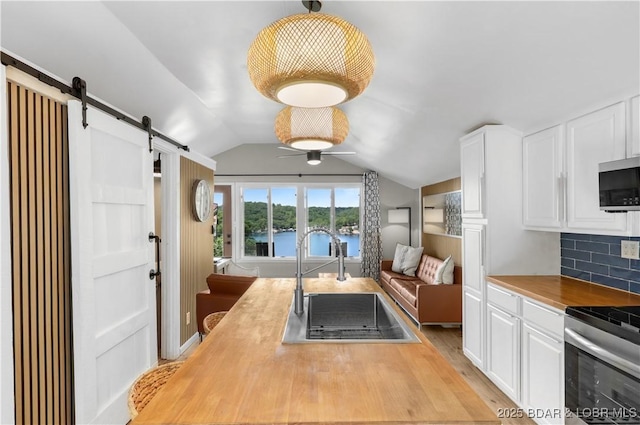 26794 Boone Rd, Barnett, MO 65011 - kitchen featuring appliances with stainless steel finishes, a barn door, wooden counters, a water view, and open floor plan