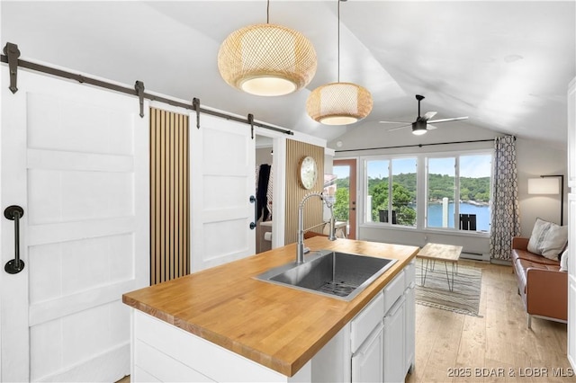 26794 Boone Rd, Barnett, MO 65011 - kitchen featuring a barn door, open floor plan, vaulted ceiling, ceiling fan, and light wood-style flooring
