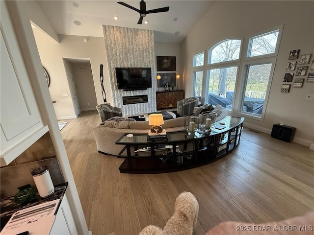 339 Cordoba Pt Unit 13B, Porto Cima, MO 65079 - living room featuring a ceiling fan, light wood-type flooring, high vaulted ceiling, and a large fireplace