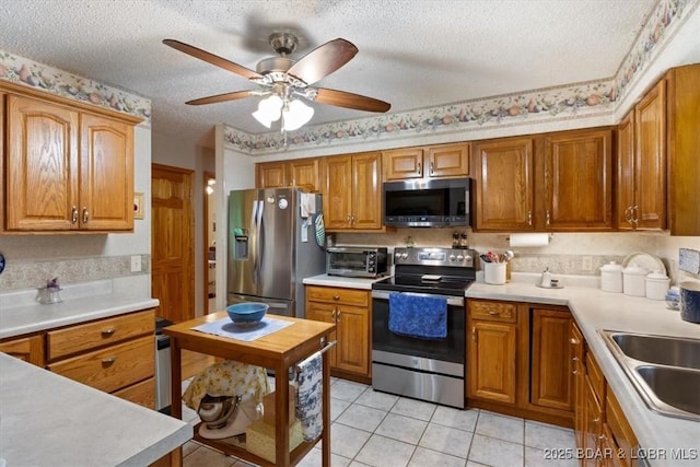 28 Wood River Rd, Lake Ozark, MO 65049 - kitchen with stainless steel appliances, a textured ceiling, brown cabinetry, light countertops, and light tile patterned flooring