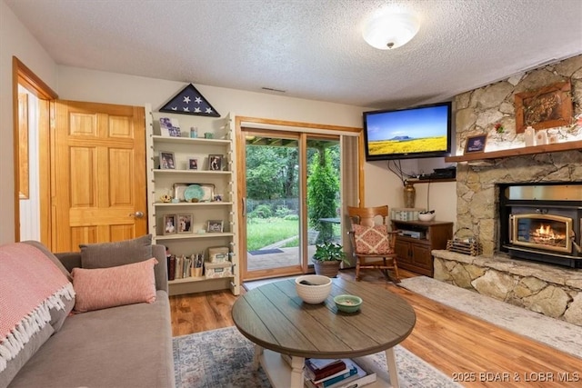 28 Wood River Rd, Lake Ozark, MO 65049 - living room featuring a textured ceiling, wood finished floors, and a fireplace