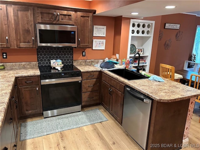 121 Banner St, Camdenton, MO 65020 - kitchen with appliances with stainless steel finishes, a peninsula, light wood-style floors, dark brown cabinetry, and recessed lighting