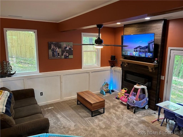 121 Banner St, Camdenton, MO 65020 - carpeted living room with crown molding, wainscoting, ceiling fan, plenty of natural light, and a large fireplace