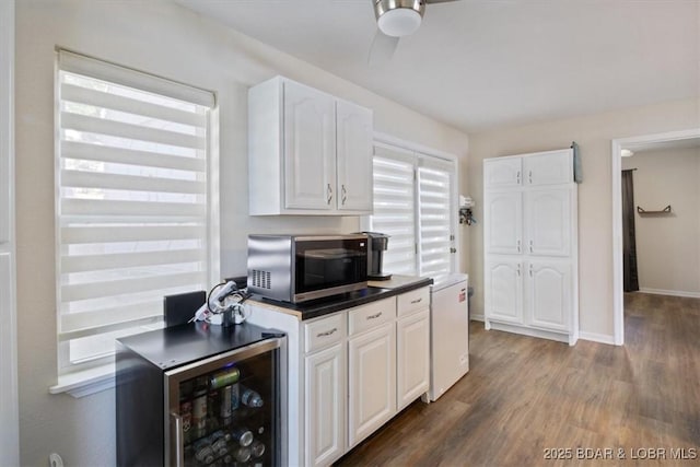27638 Golden Point Ln, Barnett, MO 65011 - kitchen featuring stainless steel microwave, beverage cooler, white cabinets, wood finished floors, and ceiling fan