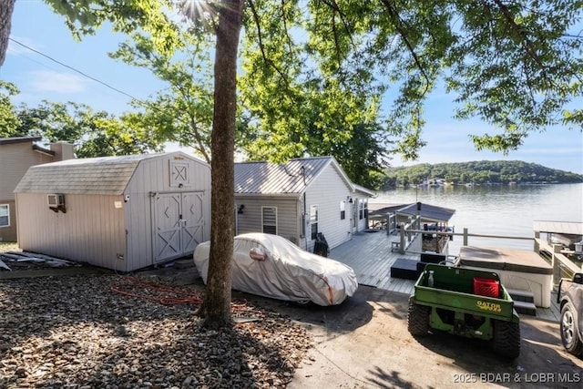 27638 Golden Point Ln, Barnett, MO 65011 - view of side of property with a water view, a storage shed, a dock, and a wall mounted air conditioner