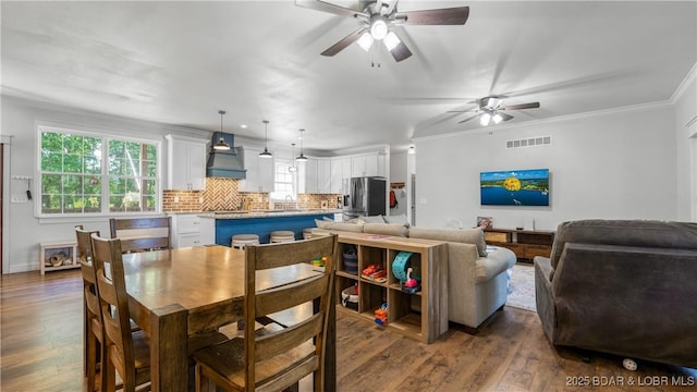 21 Winston Ln, Kaiser, MO 65047 - dining area with dark wood-style flooring, ceiling fan, and crown molding