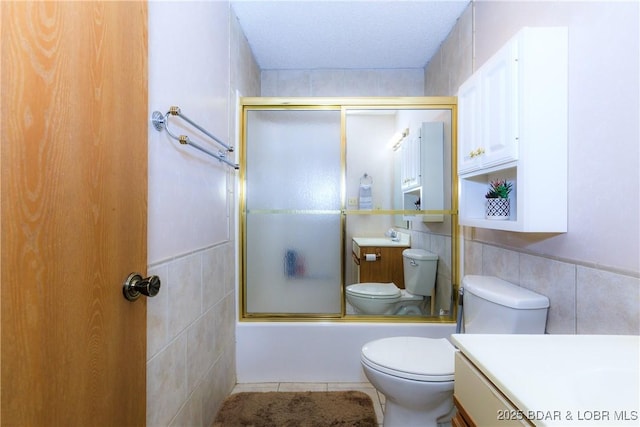 1442 Nichols Rd Unit D301, Osage Beach, MO 65065 - bathroom featuring tile walls, vanity, combined bath / shower with glass door, and tile patterned flooring