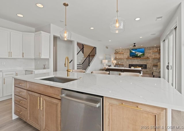 584 Black Hawk Dr, Lake Ozark, MO 65049 - kitchen featuring dishwasher, open floor plan, recessed lighting, light wood-type flooring, and a stone fireplace