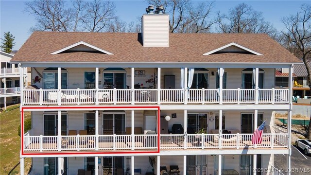 49 Aqua Fin Dr Unit 3B, Lake Ozark, MO 65049 - back of house with a chimney and a shingled roof