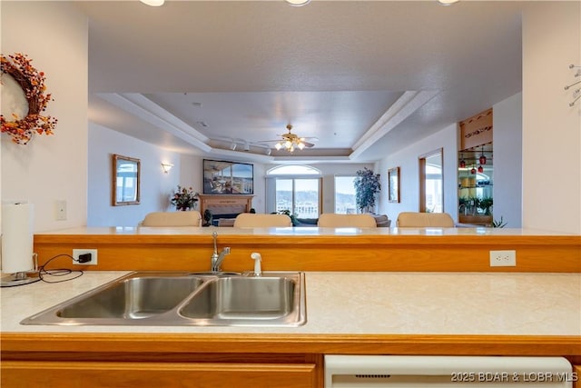49 Aqua Fin Dr Unit 3B, Lake Ozark, MO 65049 - kitchen with a tray ceiling, dishwasher, ceiling fan, a fireplace, and light countertops