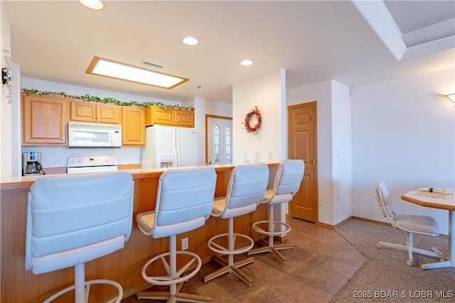 49 Aqua Fin Dr Unit 3B, Lake Ozark, MO 65049 - kitchen featuring white appliances, a breakfast bar area, recessed lighting, light countertops, and light tile patterned flooring