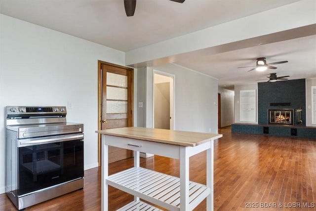43 Bob White Ln, Lake Ozark, MO 65049 - kitchen with stainless steel range with electric cooktop, a ceiling fan, wood finished floors, and a brick fireplace