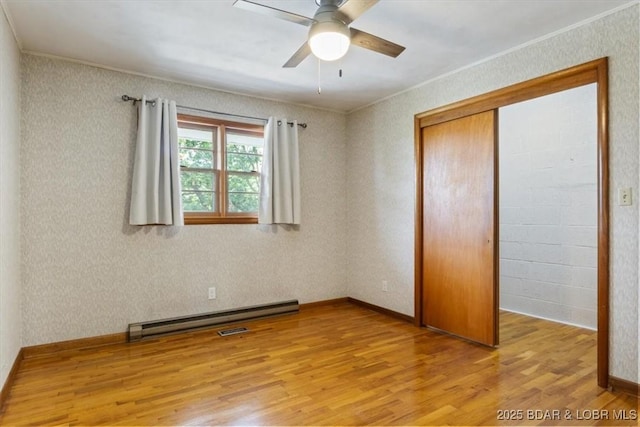 43 Bob White Ln, Lake Ozark, MO 65049 - unfurnished bedroom with light wood-style floors, ornamental molding, baseboard heating, a closet, and ceiling fan