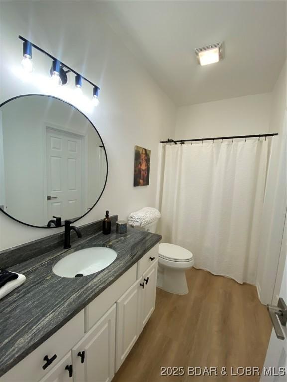 42 Palisades Lakeview Dr Unit 4B, Lake Ozark, MO 65049 - bathroom with vanity, wood finished floors, and a shower with curtain