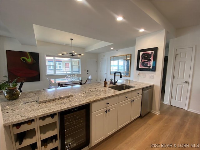 42 Palisades Lakeview Dr Unit 4B, Lake Ozark, MO 65049 - kitchen with wine cooler, dishwasher, wood finished floors, white cabinetry, and light stone countertops