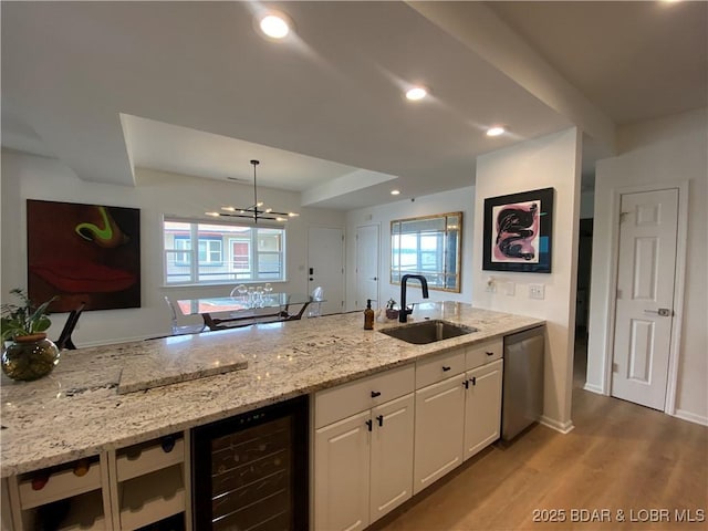 42 Palisades Lakeview Dr Unit 4B, Lake Ozark, MO 65049 - kitchen featuring wine cooler, stainless steel dishwasher, white cabinetry, wood finished floors, and light stone countertops