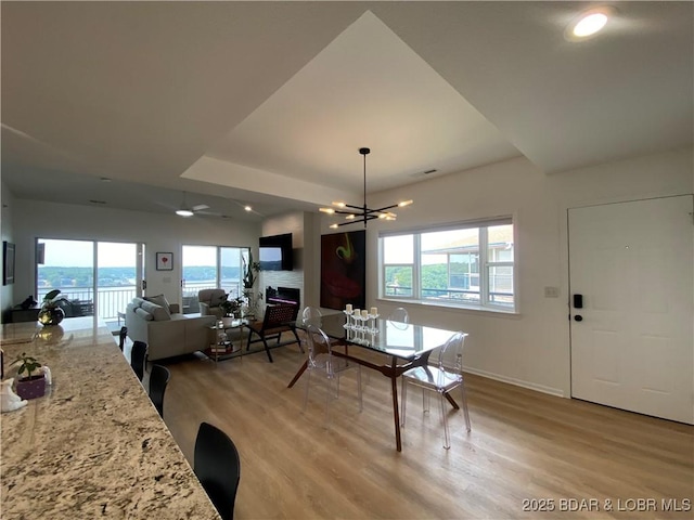 42 Palisades Lakeview Dr Unit 4B, Lake Ozark, MO 65049 - dining space featuring light wood-type flooring, healthy amount of natural light, a fireplace, a chandelier, and recessed lighting