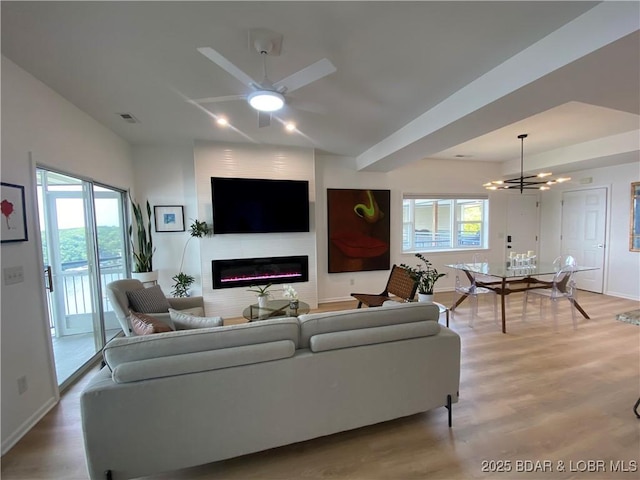 42 Palisades Lakeview Dr Unit 4B, Lake Ozark, MO 65049 - living room featuring a glass covered fireplace, healthy amount of natural light, light wood-type flooring, ceiling fan, and lofted ceiling