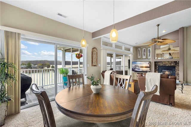 6680 Keystone Dr Unit 241, Osage Beach, MO 65065 - dining space featuring light colored carpet, a ceiling fan, a high end fireplace, and lofted ceiling