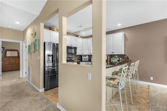 6680 Keystone Dr Unit 241, Osage Beach, MO 65065 - kitchen featuring stainless steel appliances, white cabinetry, tasteful backsplash, recessed lighting, and light tile patterned floors