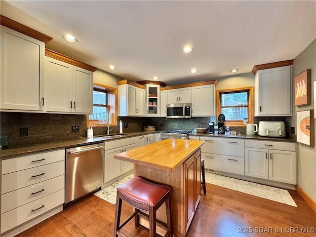 158 Oak Manor Cir, Sunrise Beach, MO 65079 - kitchen with appliances with stainless steel finishes, butcher block counters, light wood-style flooring, tasteful backsplash, and recessed lighting