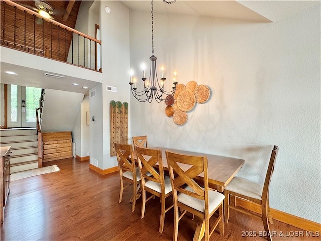 158 Oak Manor Cir, Sunrise Beach, MO 65079 - dining space featuring stairs, wood finished floors, a chandelier, and lofted ceiling