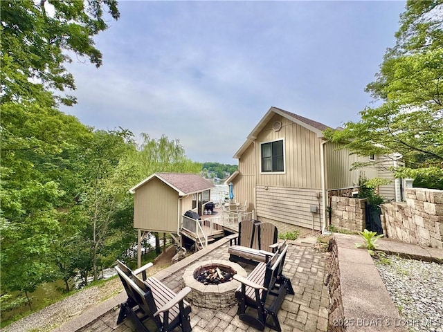 158 Oak Manor Cir, Sunrise Beach, MO 65079 - back of house featuring a fire pit, a patio area, a deck, and an outdoor structure