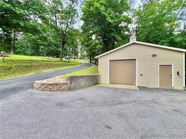 158 Oak Manor Cir, Sunrise Beach, MO 65079 - detached garage featuring asphalt driveway and view of wooded area