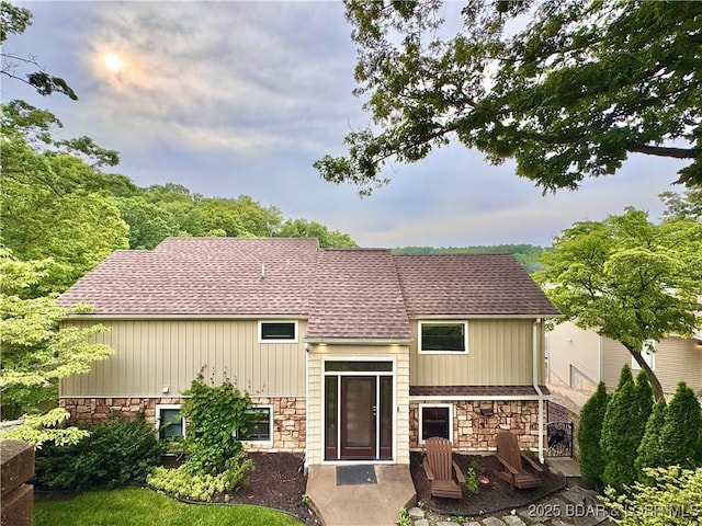 158 Oak Manor Cir, Sunrise Beach, MO 65079 - rear view of house with stone siding, roof with shingles, and a patio