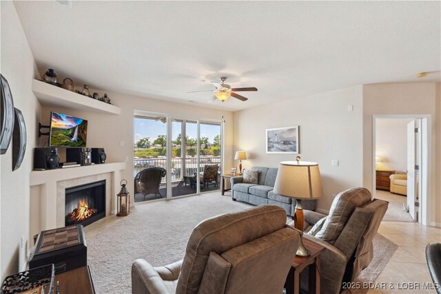 18136 Millstone Cove Rd Unit 136, Gravois Mills, MO 65037 - living room with a lit fireplace, ceiling fan, light colored carpet, and light tile patterned floors