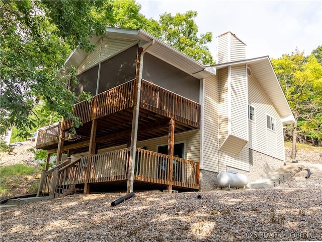 1403 Ginger Rd, Lake Ozark, MO 65049 - rear view of house with a chimney, a wooden deck, and a sunroom