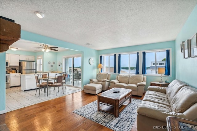 1113 Passover Rd Unit M-3, Osage Beach, MO 65065 - living area with light wood-style floors, a textured ceiling, and ceiling fan