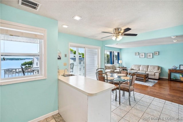 1113 Passover Rd Unit M-3, Osage Beach, MO 65065 - kitchen featuring ceiling fan, light tile patterned flooring, a peninsula, light countertops, and a textured ceiling