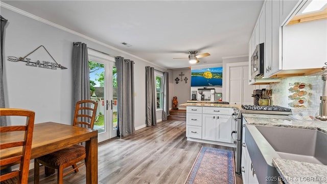 168 Moeller Way, Camdenton, MO 65020 - kitchen with appliances with stainless steel finishes, a peninsula, white cabinets, light wood finished floors, and crown molding