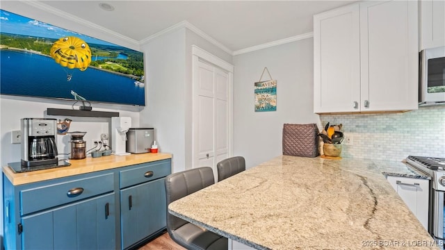 168 Moeller Way, Camdenton, MO 65020 - kitchen featuring stainless steel microwave, tasteful backsplash, blue cabinetry, crown molding, and light stone counters